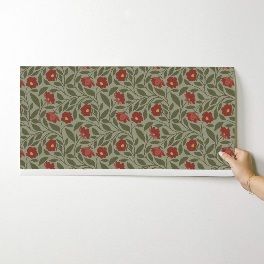 Floral patterned mat on a white surface with a hand holding it
