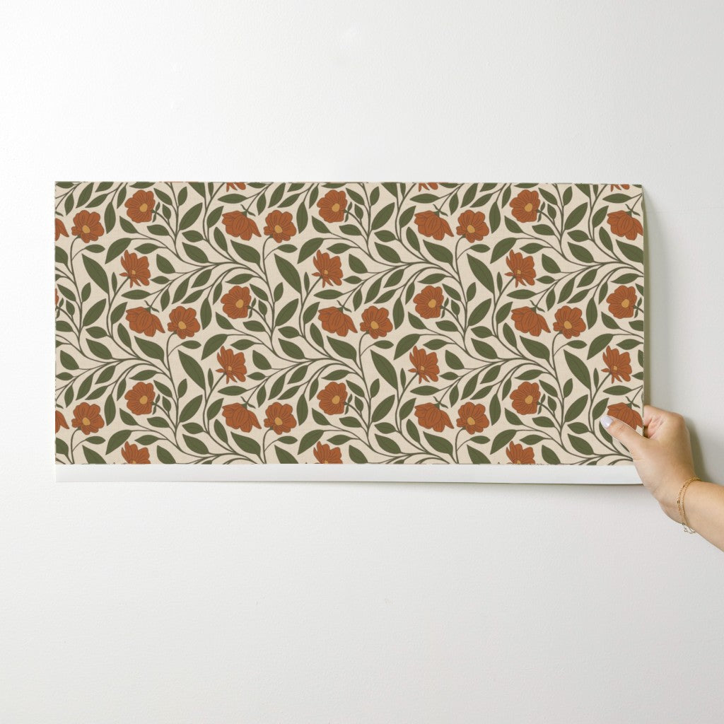 Hand holding a floral patterned mat on a white background