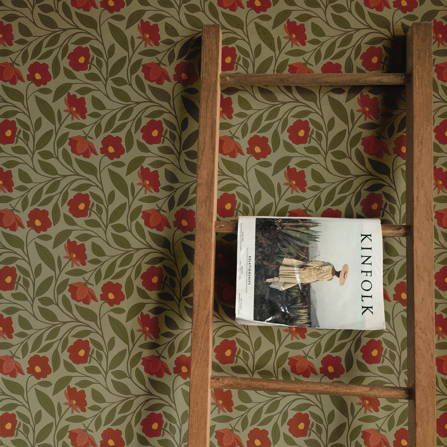 Wooden shelf with a 'KINFOLK' magazine against a floral-patterned wall.